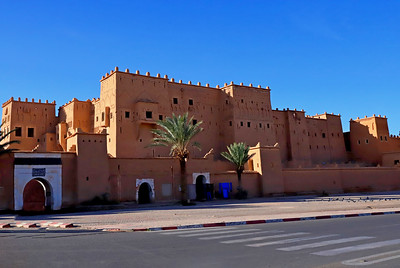 a man in a blue robe walking through a kasbah taourirt ouarzazate on Desert tours from fes